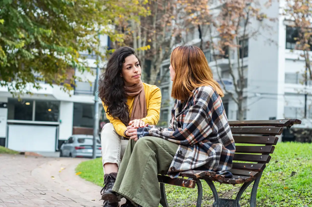How Can I Help Someone With Alcohol Addiction? An image of two friends talking on a bench